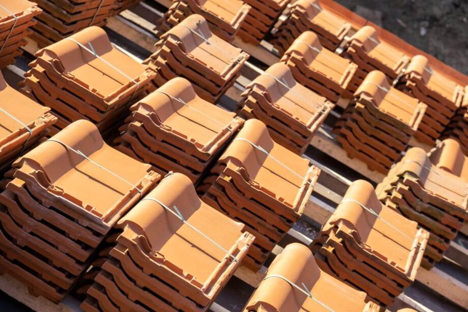 Stosy dachówek ceramicznych ułożone na paletach.