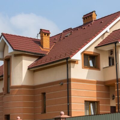 Ceglane dachy ozdabiają elegancki dom z brązową elewacją.